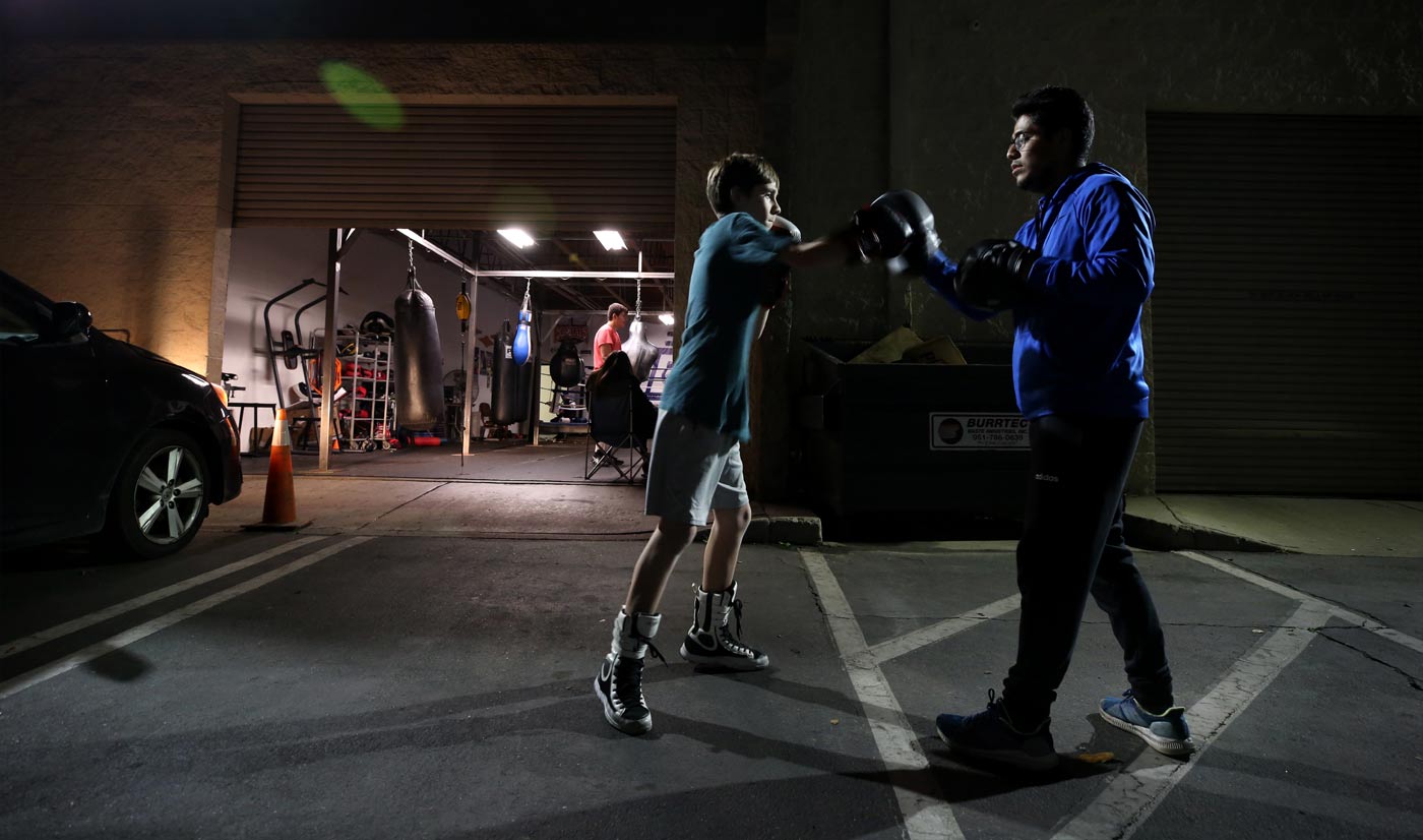 UC Riverside alumnus Jose Jimenez ’16 works on boxing techniques with Jared Hilley, 14, of Riverside, on Jan. 21." 